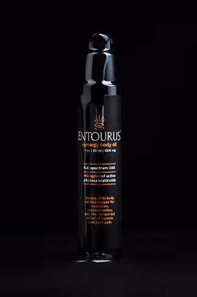 Entourus black bottle centered on black background with orange label, product photography by Photos by Lars.