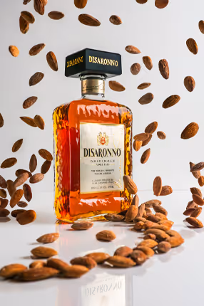 Disaronno bottle framed by coffee beans on white background, product photography by Photos by Lars.