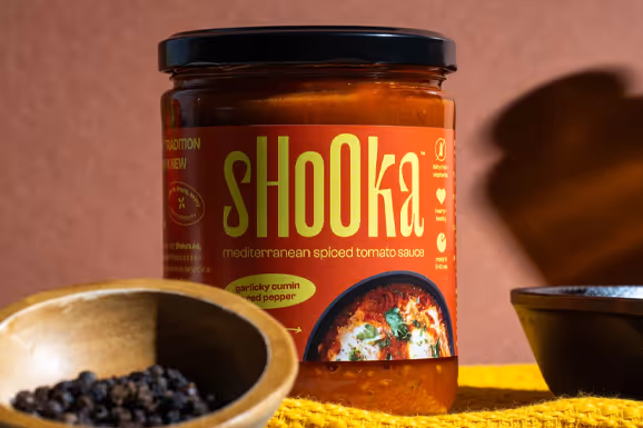 Shooka sauce jar close-up with a bowl of peppercorns and spices, food photography by Photos by Lars.