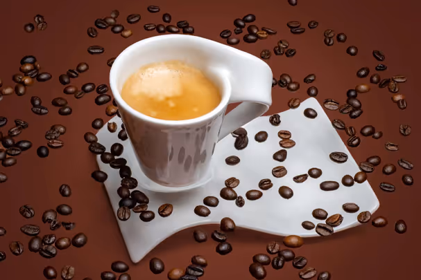 Espresso in white cup on napkin surrounded by coffee beans, food photography by Photos by Lars.