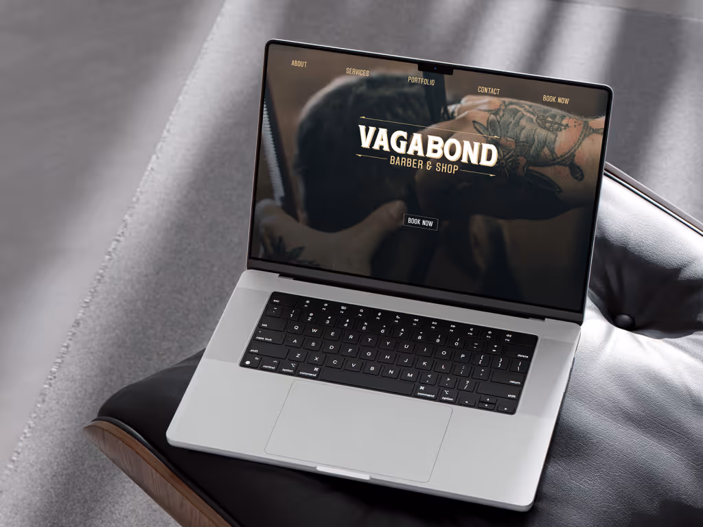 : A mockup of the Vagabond Barber & Shop website homepage, with its dark, moody design, shown on a laptop.