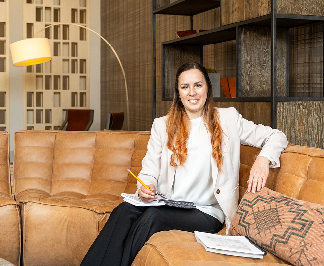 Tax professional sitting on a sofa while reviewing client paperwork.