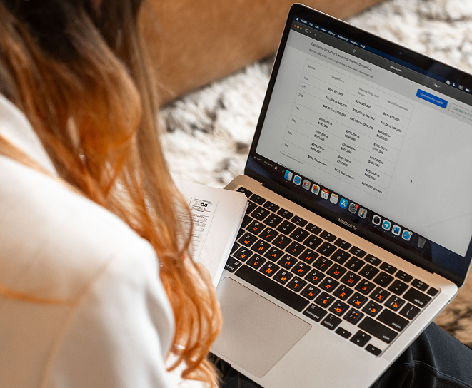 Charlotte tax preparer reviewing financial data on a laptop.