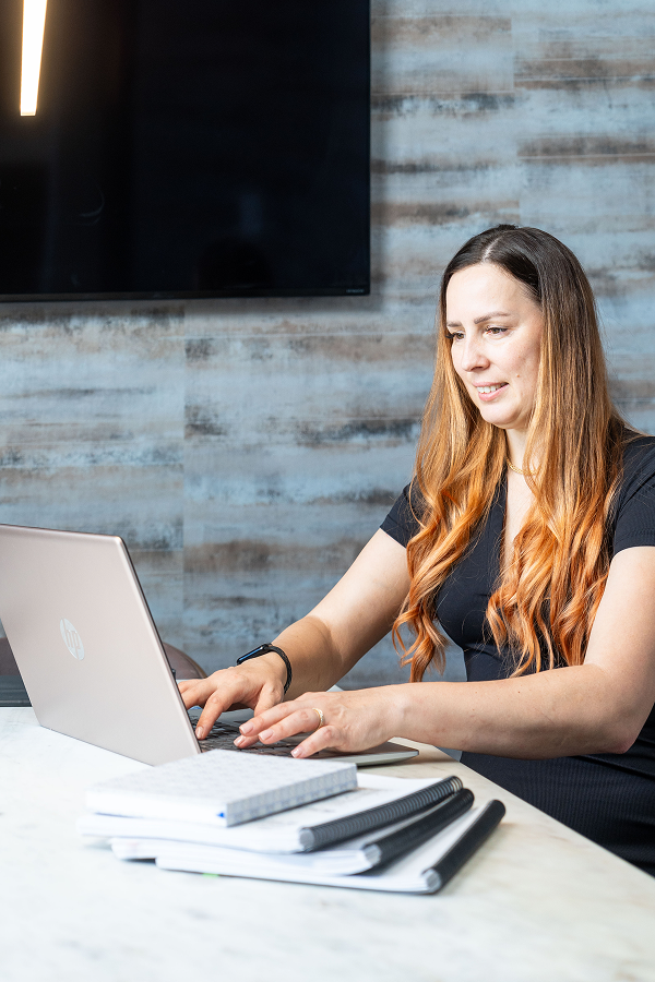 Tax professional working on a laptop while reviewing documents.
