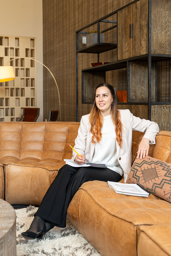 Tax professional sitting on a leather sofa reviewing paperwork.