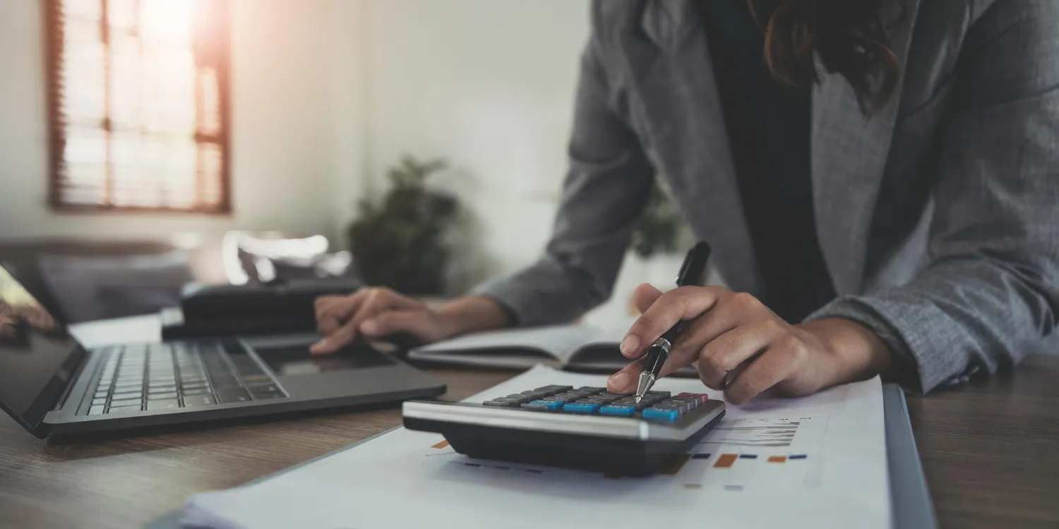 Person using a calculator and laptop