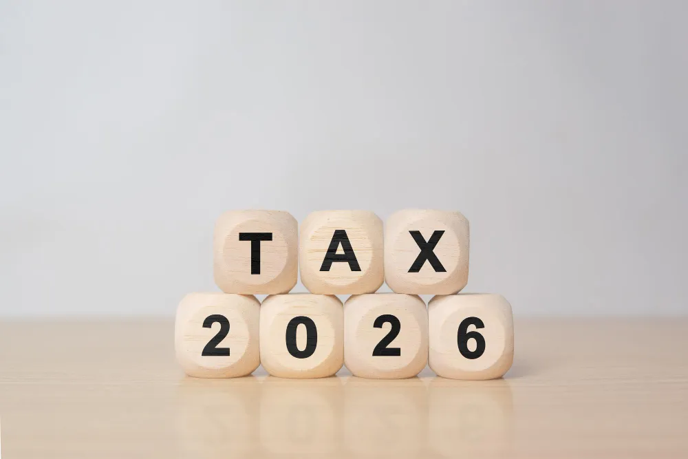 Wooden blocks spelling TAX 2026 on table