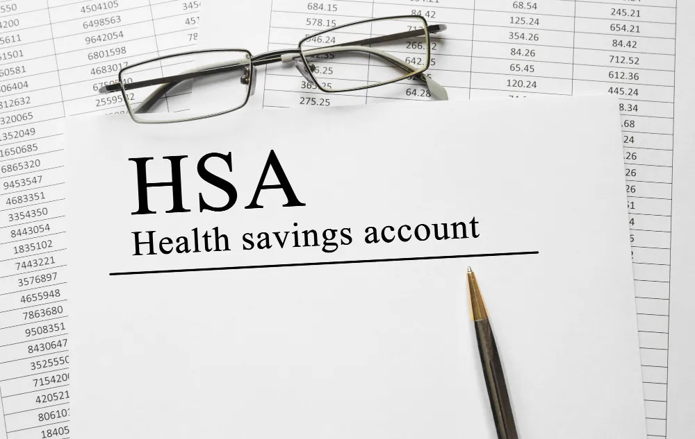 HSA health savings account document with glasses and pen