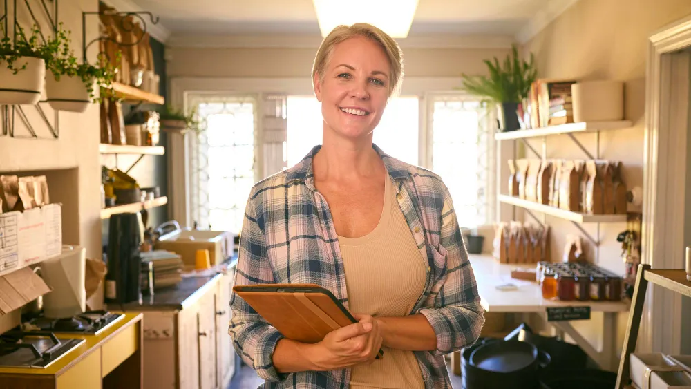 Small business owner holding tablet in shop