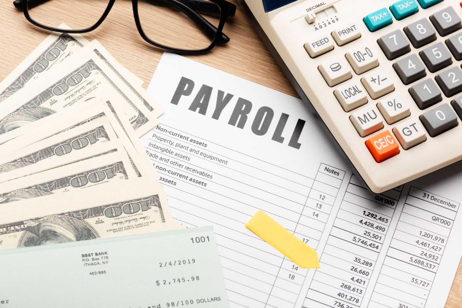 Payroll documents with calculator and cash