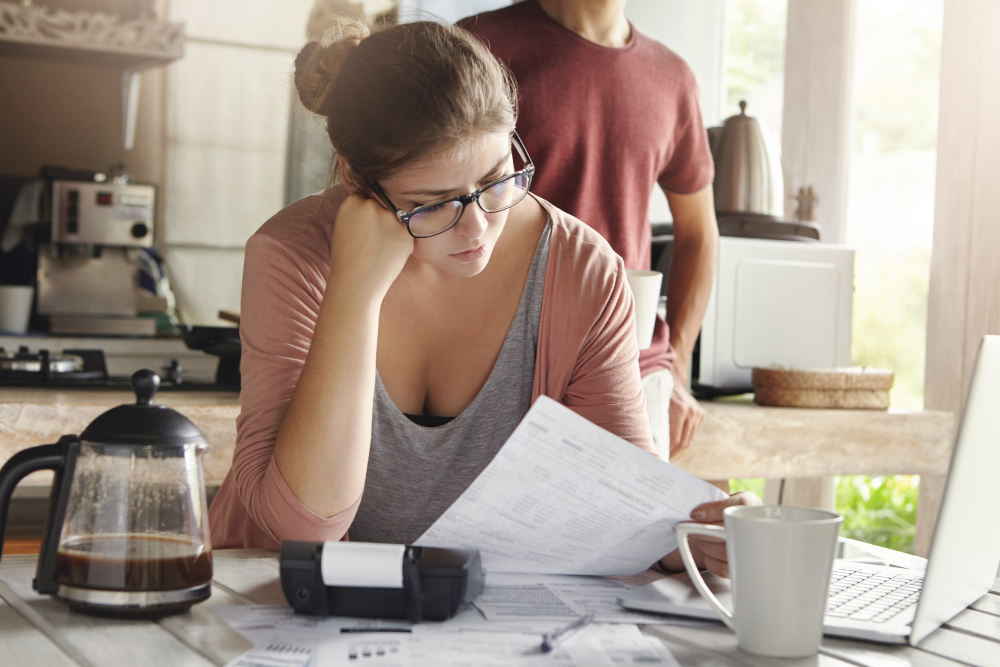 Couple reviewing tax documents and discussing taxes at home.