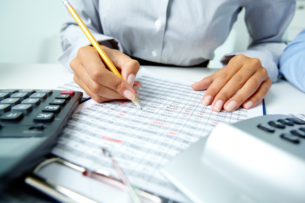 Employee payroll worksheet being reviewed with calculators