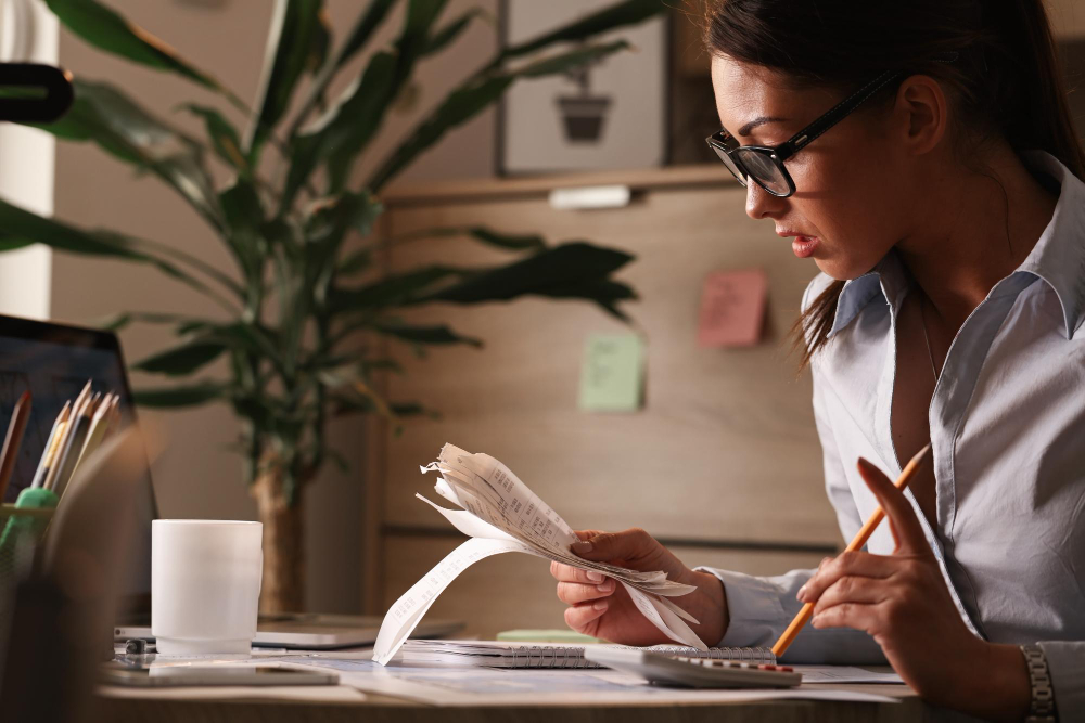 Woman reviewing tax documents and calculating expenses
