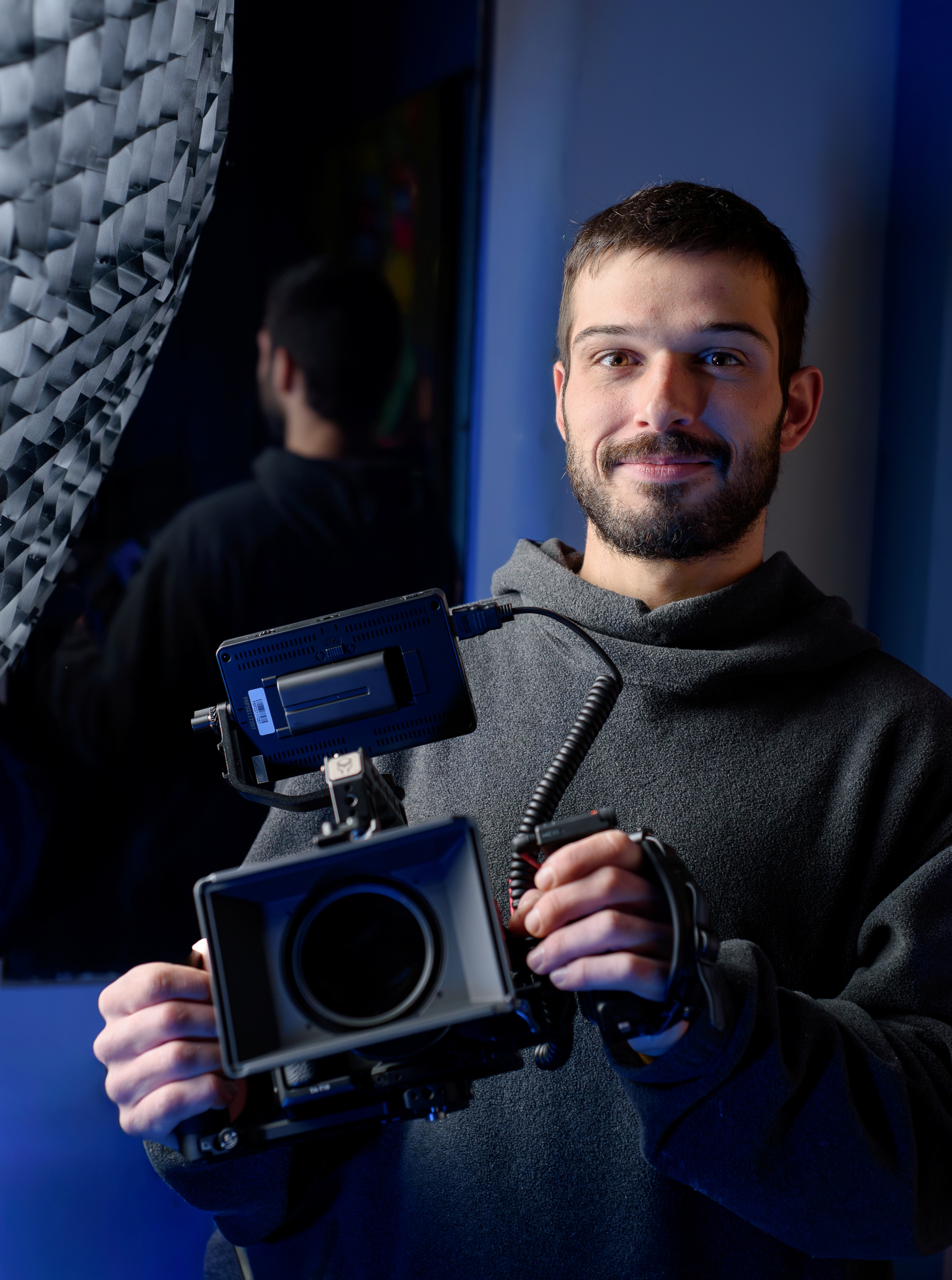 Vidéaste professionnel tenant une caméra cinéma en studio lors d’un tournage vidéo