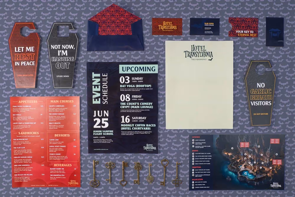 Printed posters, cards, and tags arranged on blue textured background, product photography by Photos by Lars.