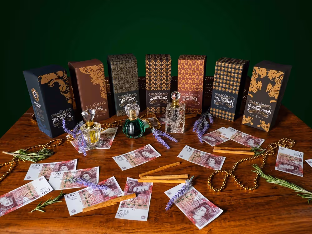 Tabletop spread of boxed products, small jars, and glassware on green backdrop, product photography by Photos by Lars.