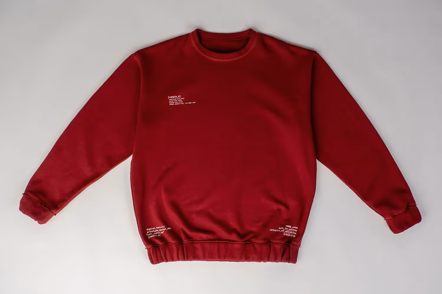 Red crewneck sweatshirt laid flat on light gray backdrop, apparel photography by Photos by Lars.