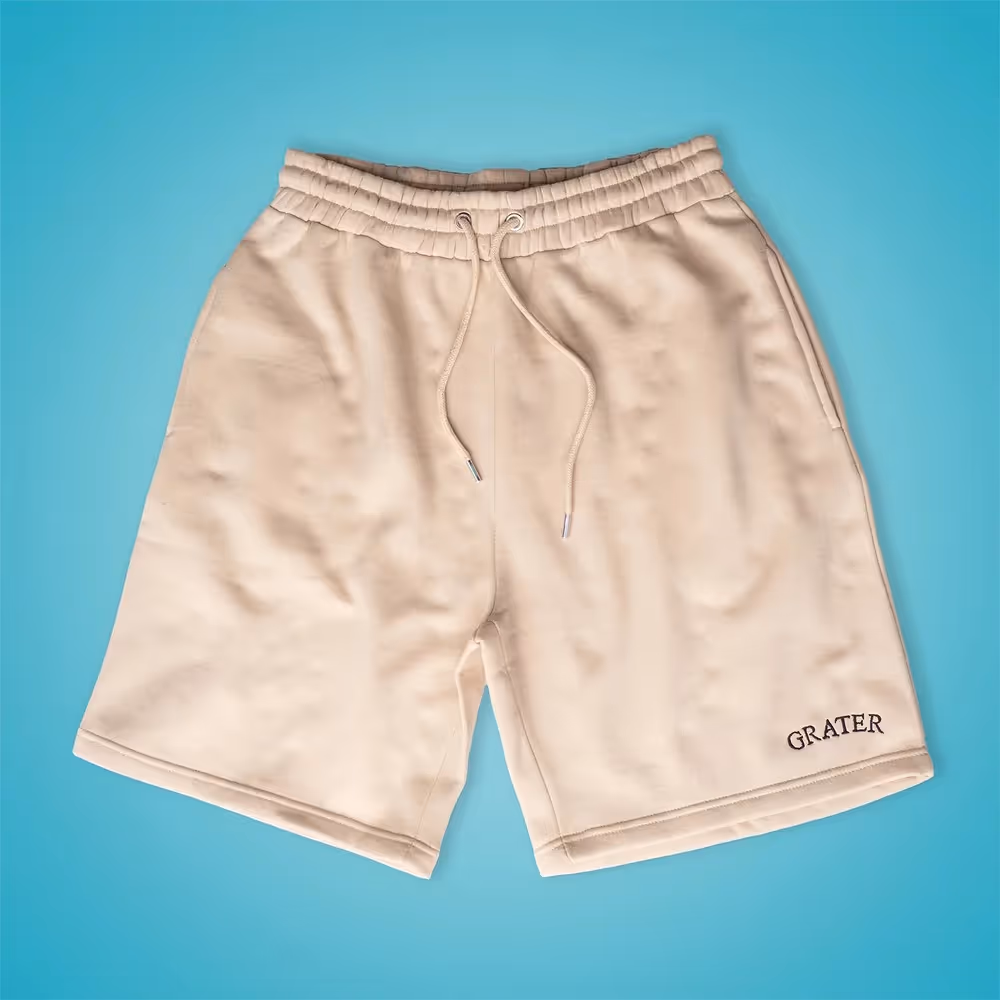 Cream Grater Things shorts laid flat on teal background, ecommerce product photography by Photos by Lars.