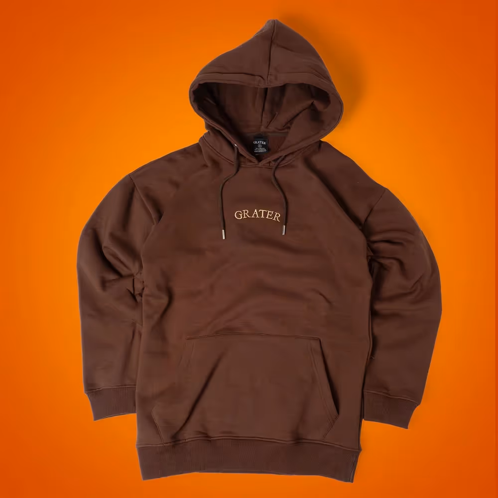 Brown Grater Things hoodie laid flat on orange background, ecommerce apparel photography by Photos by Lars.