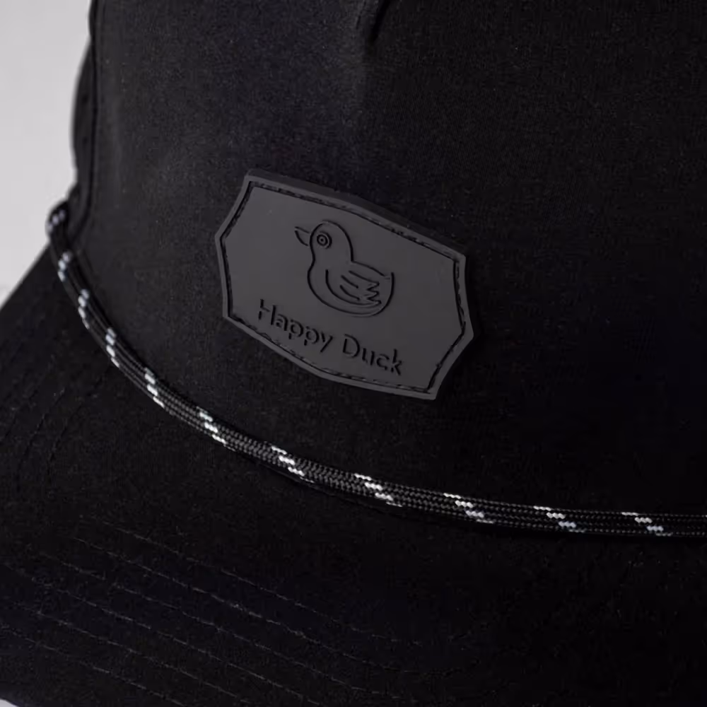 Close-up of black cap with Happy Duck logo patch and stitched brim, product photography by Photos by Lars.