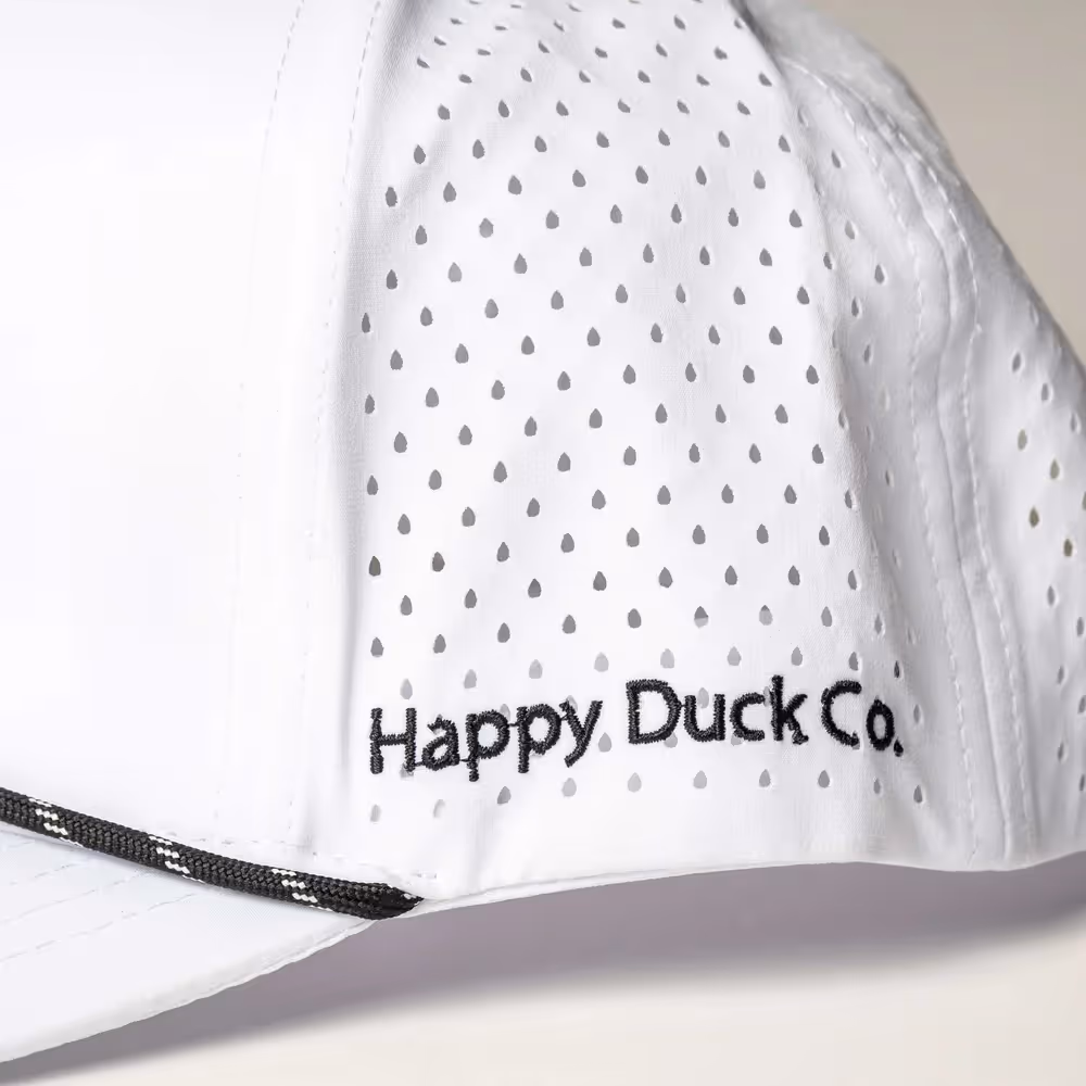 Close-up of white cap with 'Happy Duck Co.' embroidery on side panel, apparel photography by Photos by Lars.