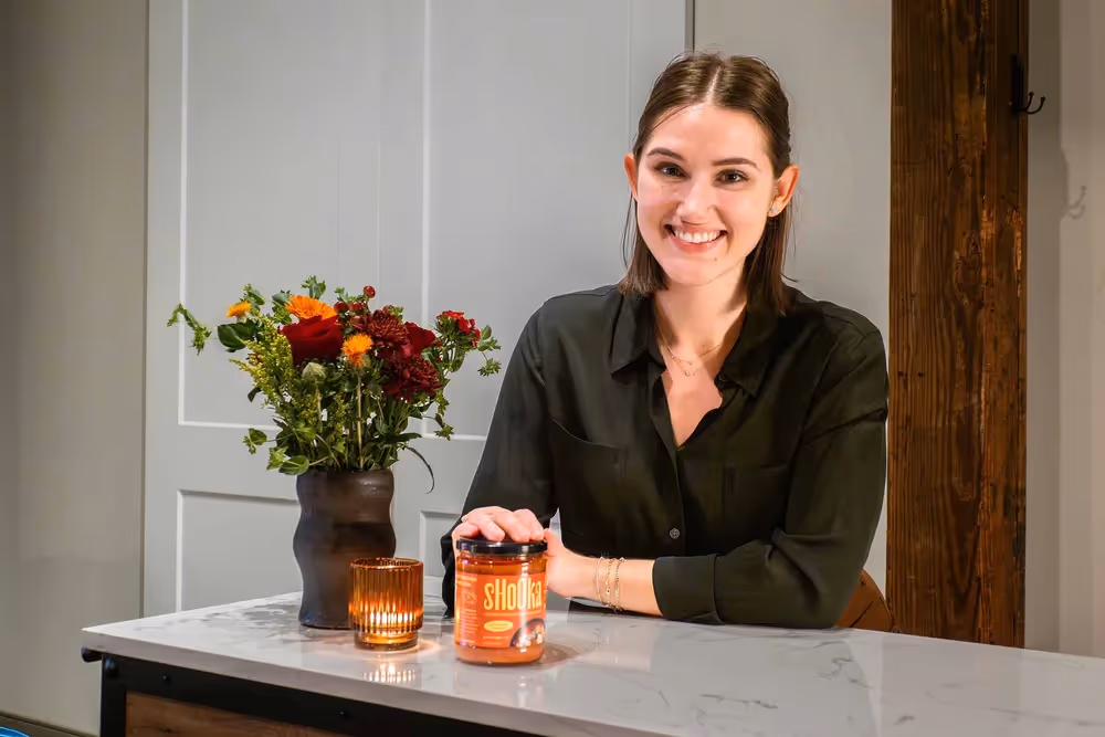 Person seated at kitchen island with flowers and candles, lifestyle portrait photography by Photos by Lars.