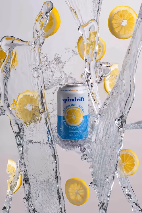 Spindrift Lemon can caught in a clear water splash with lemon slices, product photography by Photos by Lars.
