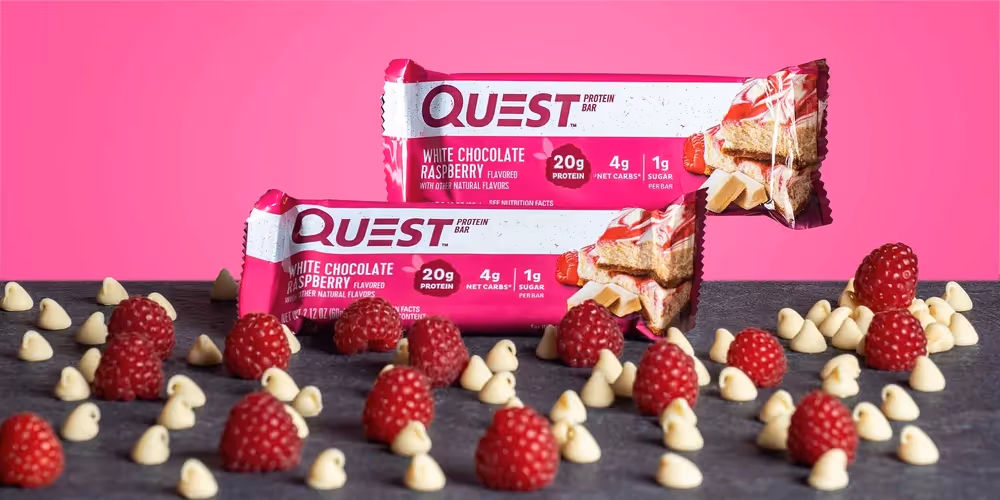 Two Quest White Chocolate Raspberry bars with raspberries and white chips on pink, food photography by Photos by Lars.
