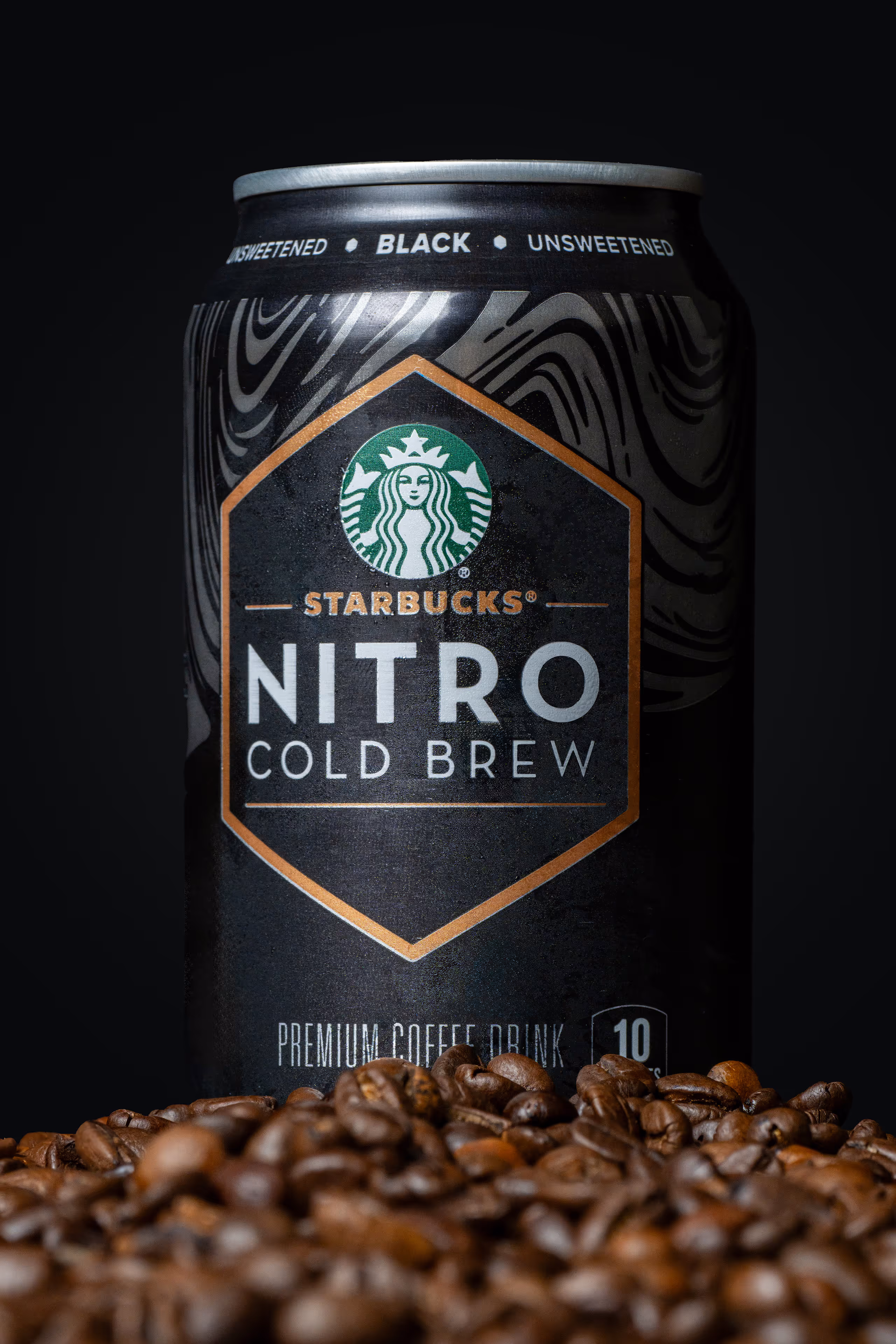 Starbucks Nitro Cold Brew can standing on coffee beans against black background, product photography by Photos by Lars.