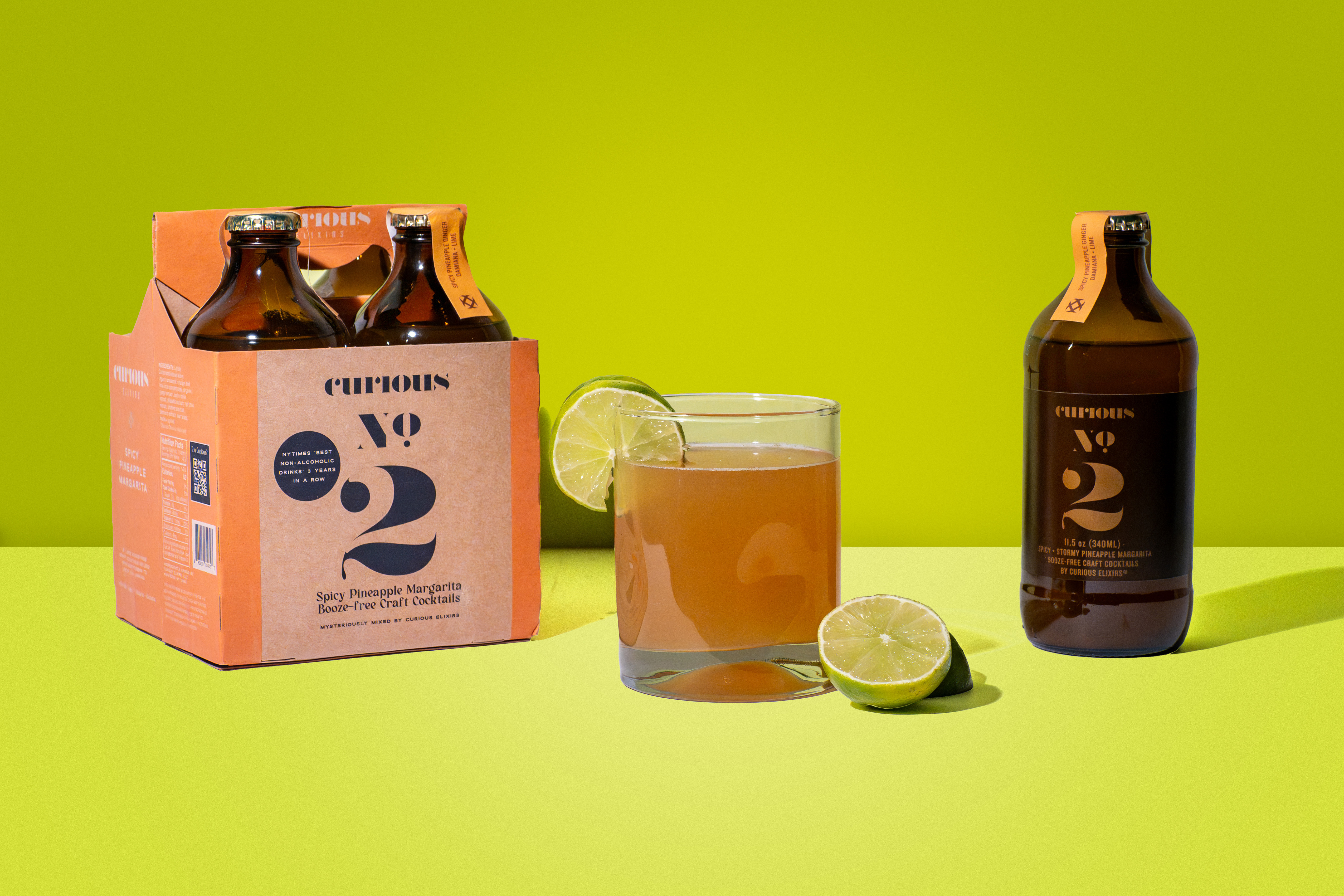 Curious Elixir No. 2 bottles and margarita cocktail with lime on green backdrop, product photography, Photos by Lars.