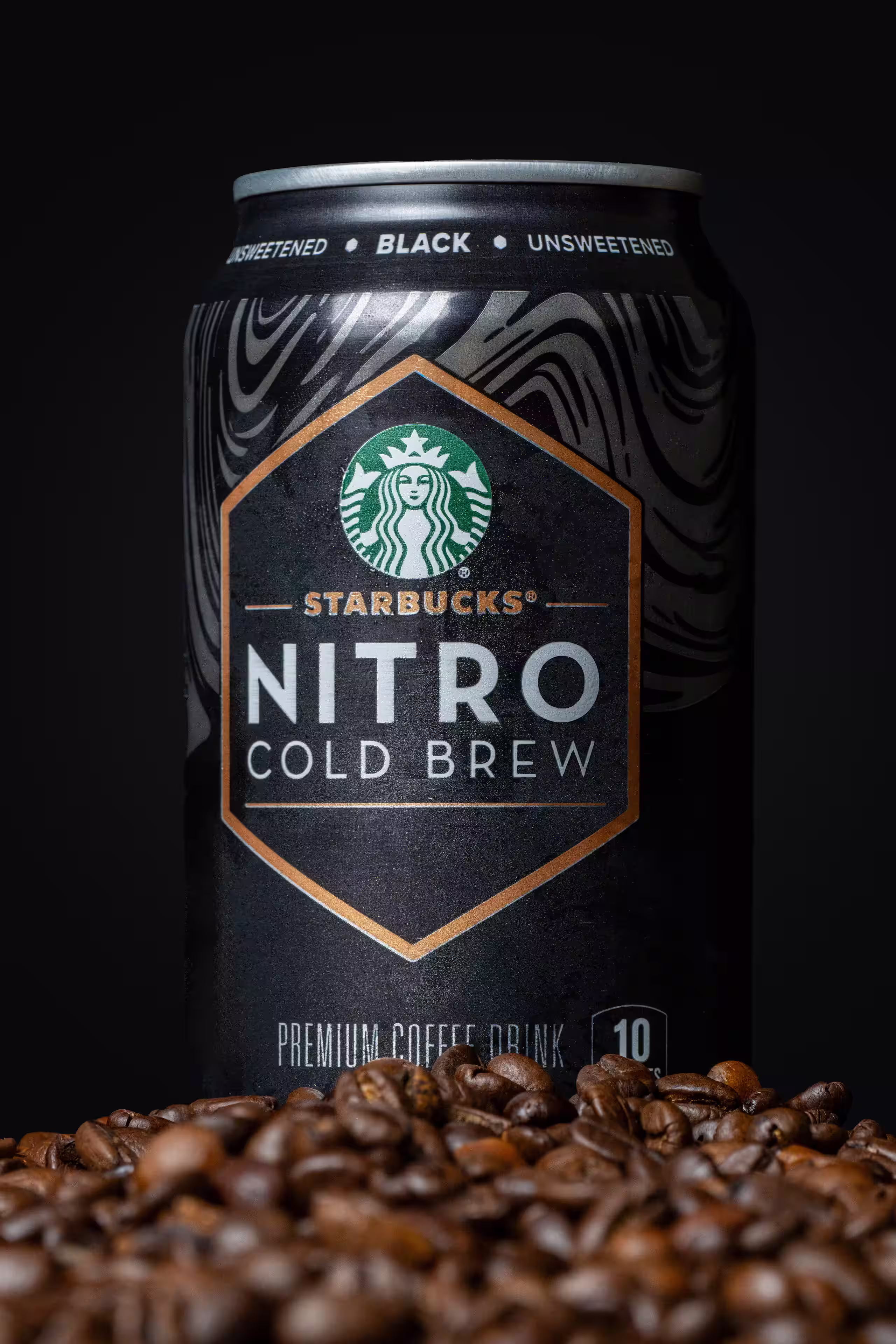 Starbucks Nitro Cold Brew can standing on coffee beans against black background, product photography by Photos by Lars.