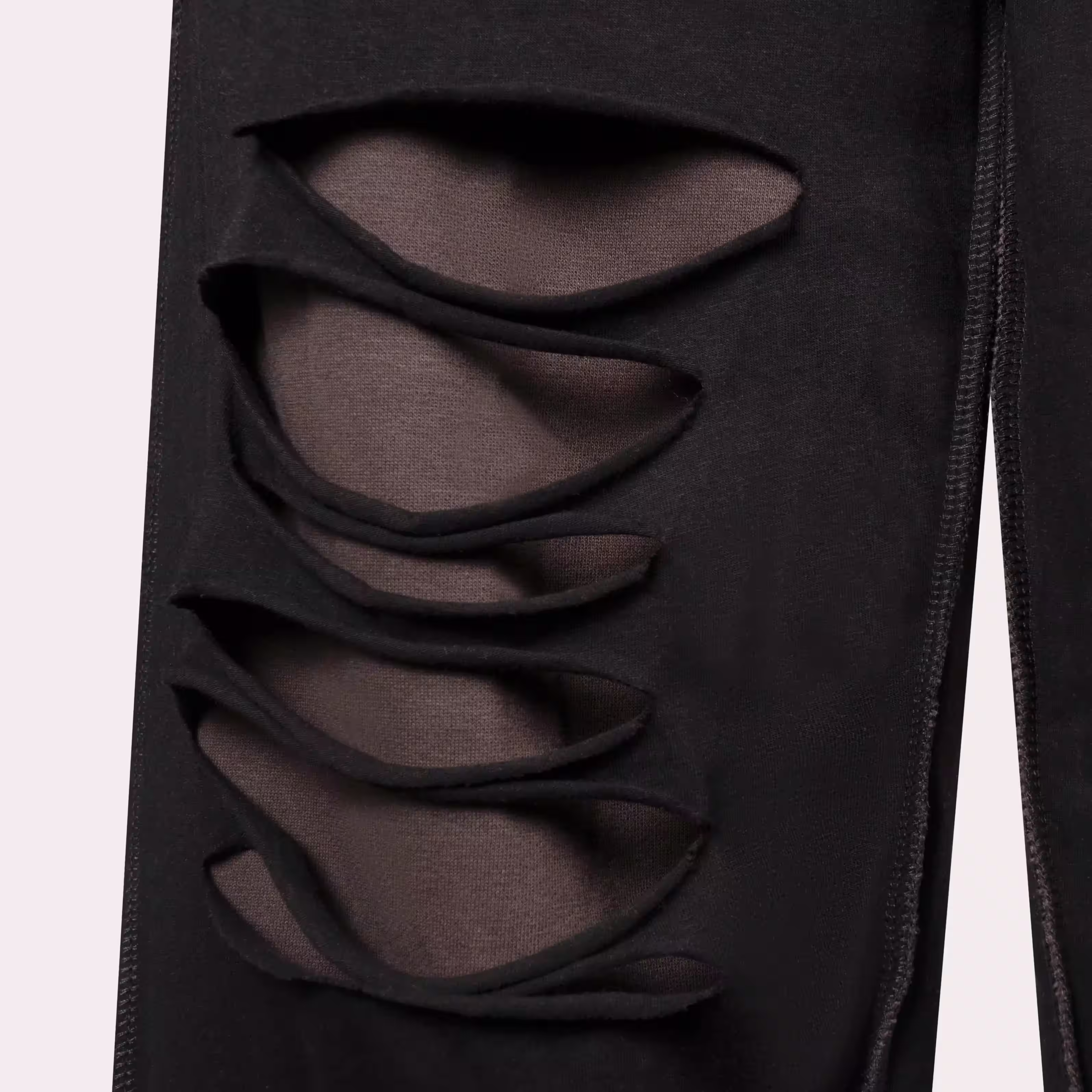 Close-up of black garment with crisscross lace-up cutouts, detail apparel photography by Photos by Lars.