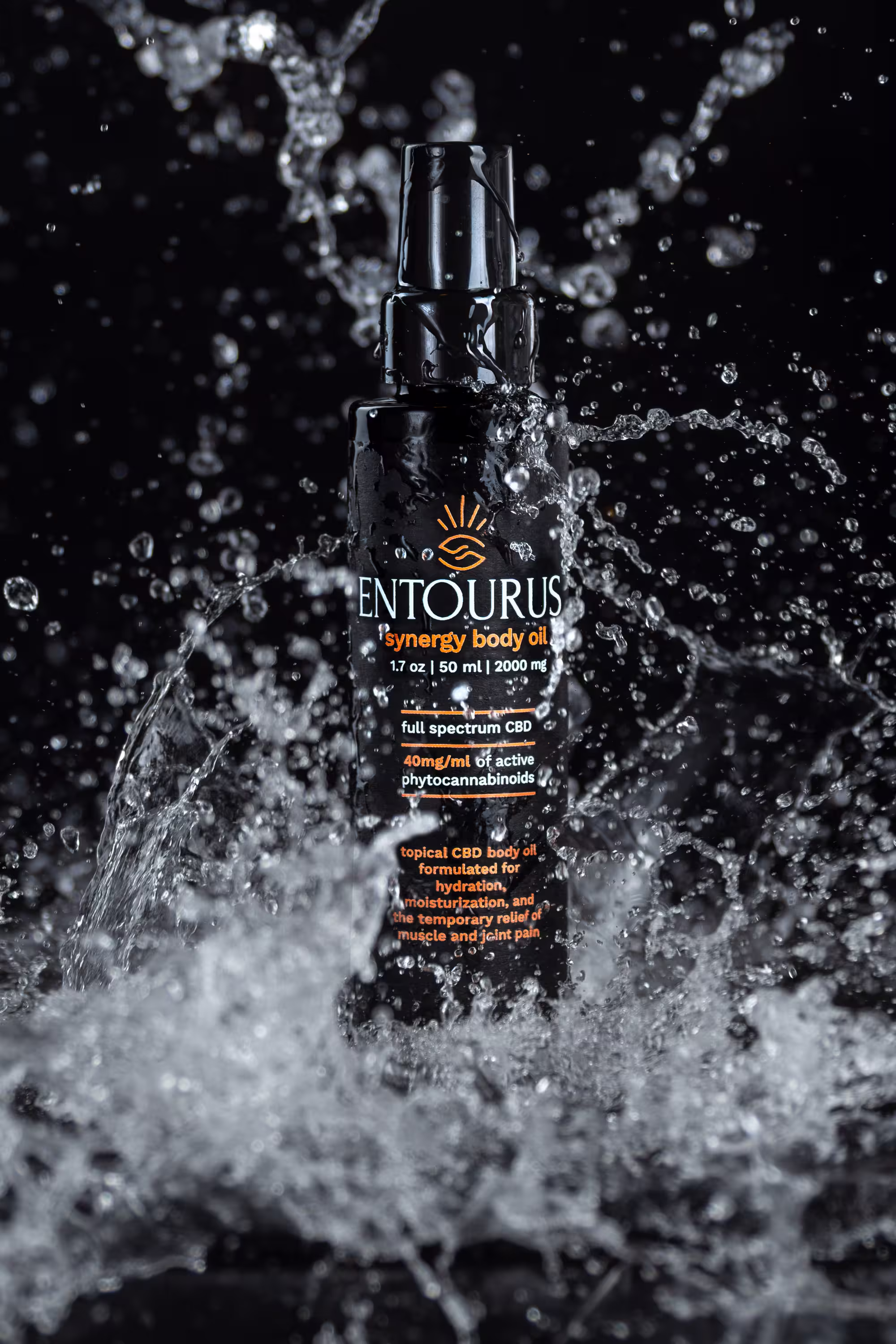 Entourus synergy body oil bottle with water splash on black background, dramatic product photo, Photos by Lars.