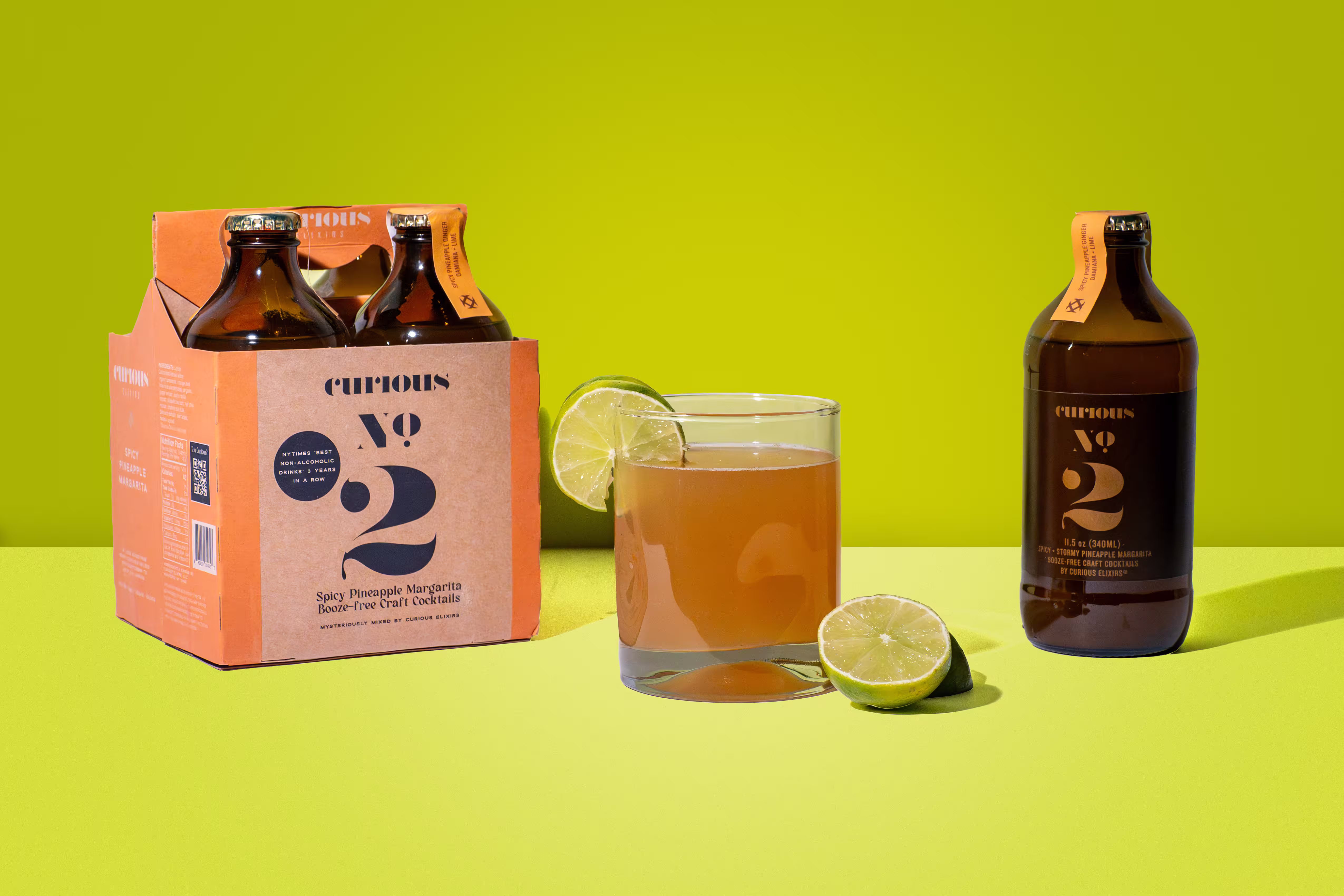 Curious Elixir No. 2 bottles and margarita cocktail with lime on green backdrop, product photography, Photos by Lars.