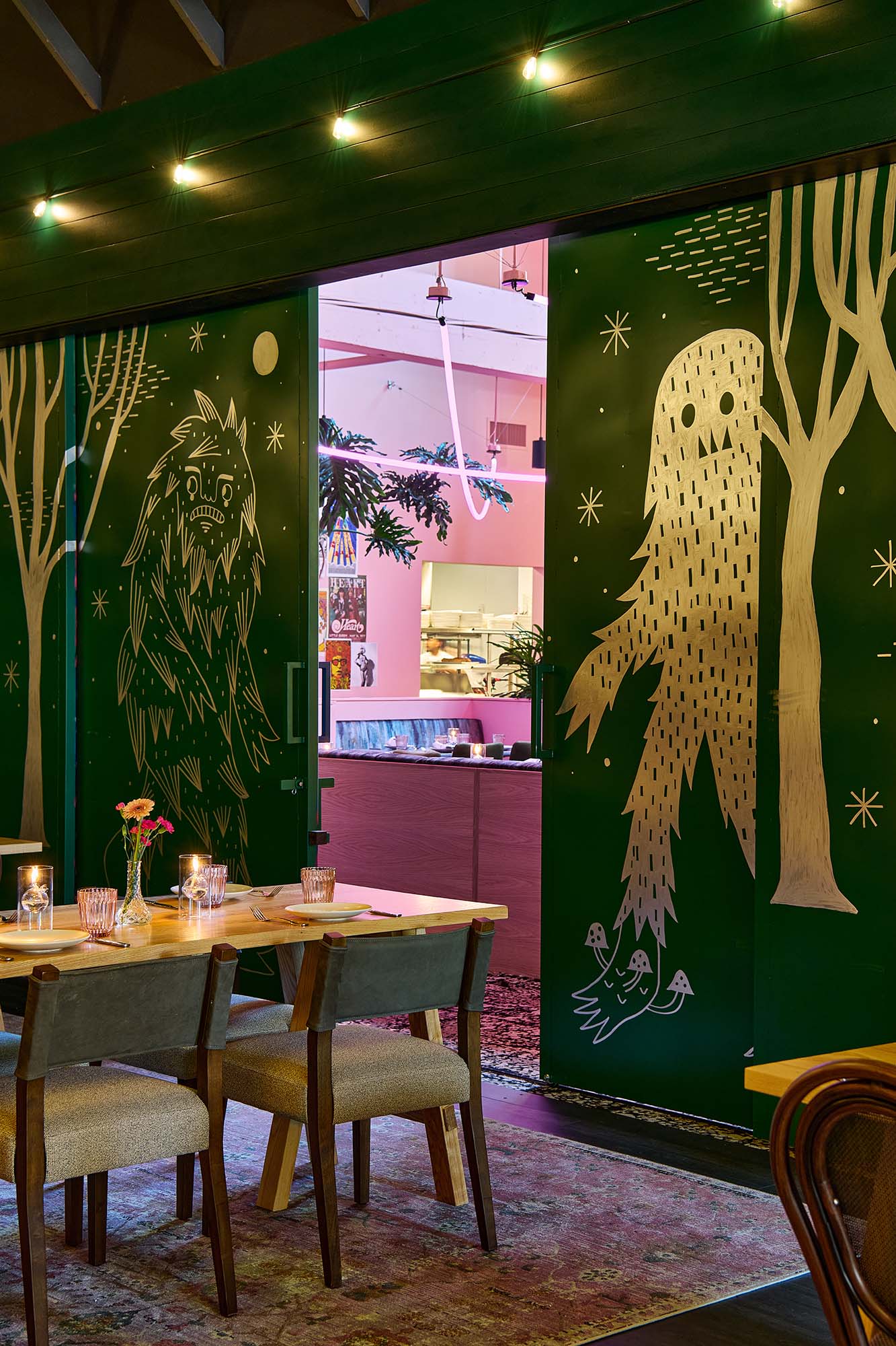 Forest Room at The Malarkey in Portland, designed by Tricorn Black, featuring custom Bigfoot mural doors, deep green walls and layered restaurant furnishings.