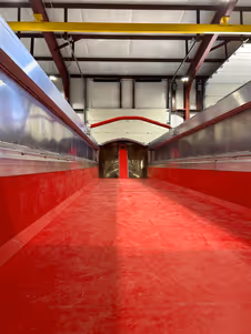 Interior of a red and white industrial space with metal walls and visible ceiling beams.