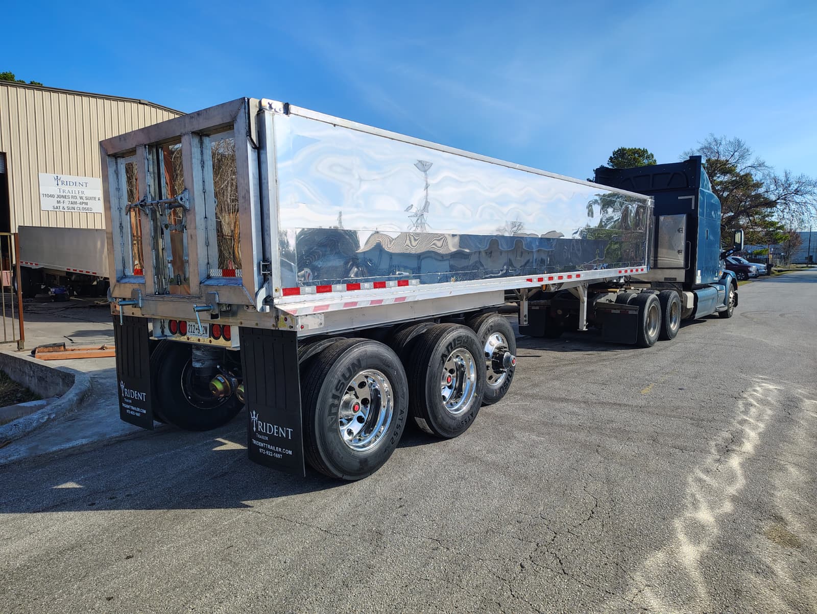 Red Truck pulling aluminum Trident Trailer