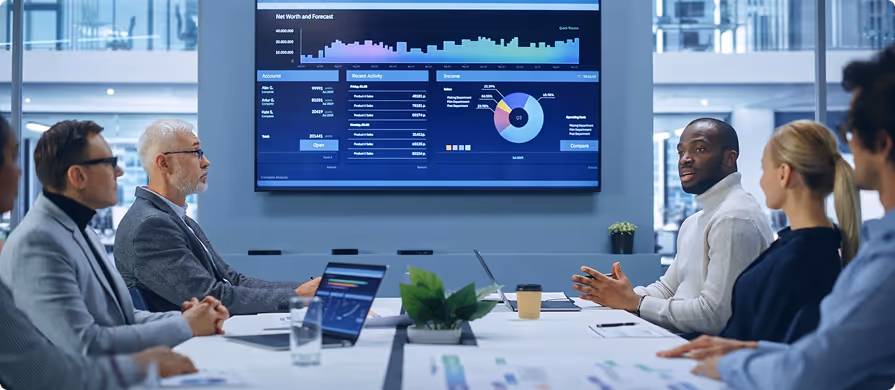 A team of diverse professionals having a business meeting with data charts displayed on a screen in a modern office.