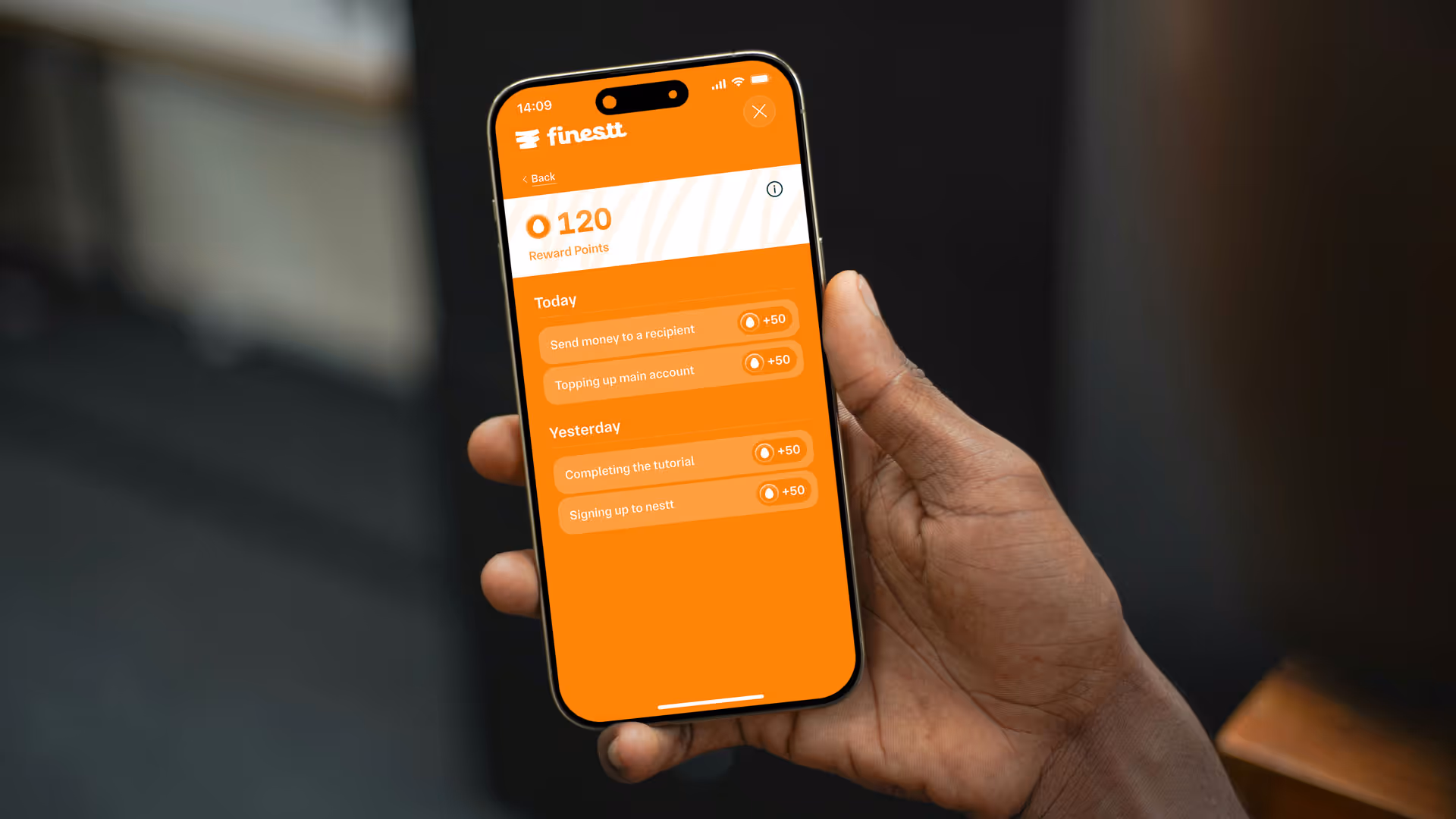 Hand holding a smartphone displaying an orange app screen showing 120 reward points and recent activities like sending money and completing tutorials.