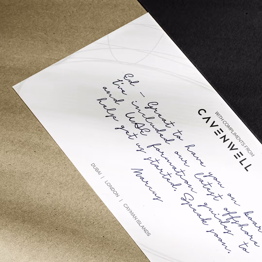 Compliments slip from Cavenwell with handwritten note about including the latest offshore and USE foundation guides, signed by Marcus, laid on a brown surface.