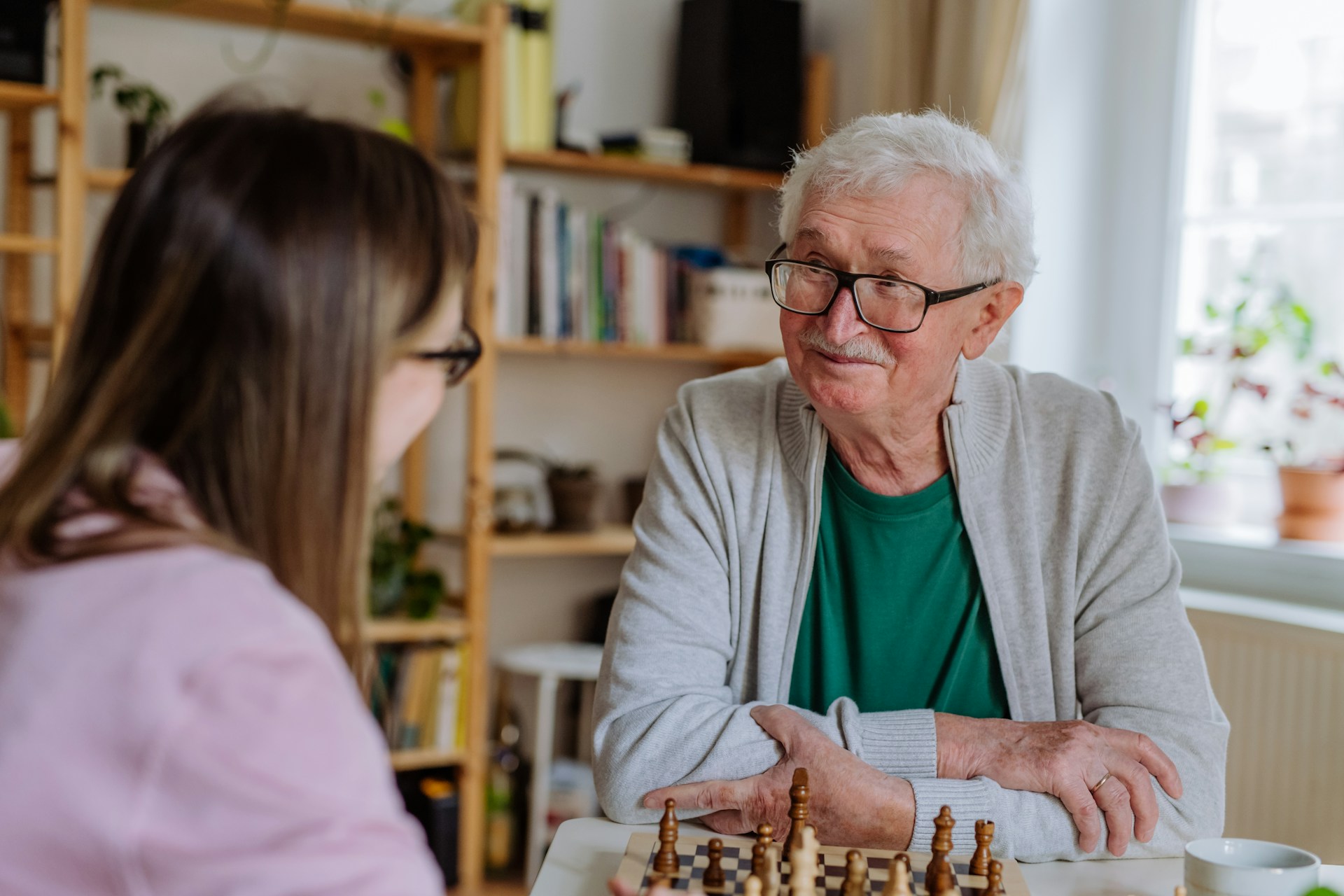 Senior jouant aux echecs avec sa dame de compagnie