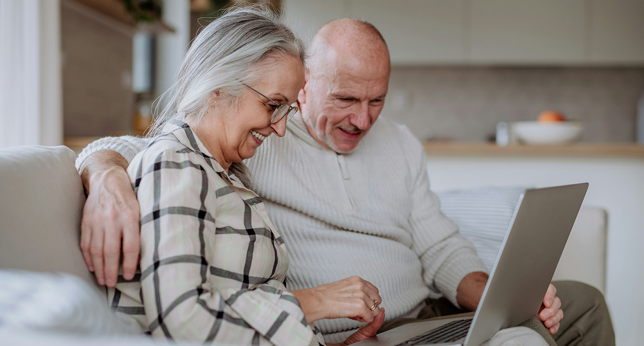 Un couple de seniors étudie un guide complet en ligne qui détaille le fonctionnement du crédit d'impôt immédiat pour l'aide à domicile