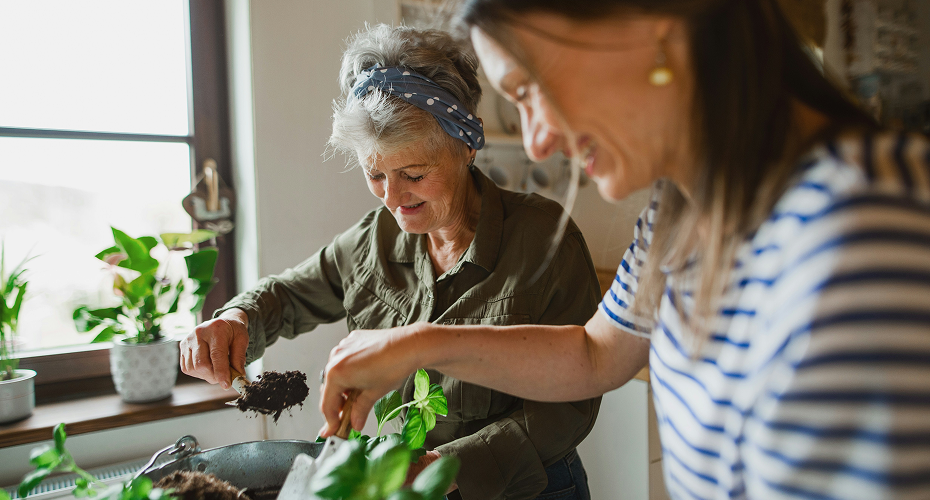 Une aide a domicile au début de sa reconversion professionnelle dans ce secteur partageant un moment de complicité avec une bénéficiaire dans sa cuisine