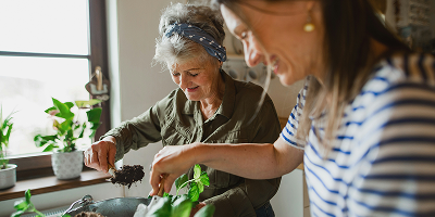 Une aide a domicile au début de sa reconversion professionnelle dans ce secteur partageant un moment de complicité avec une bénéficiaire dans sa cuisine
