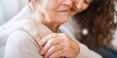 Aidante avec son proche âgée, une vielle dame en perte d'autonomie entrain de se faire un calin