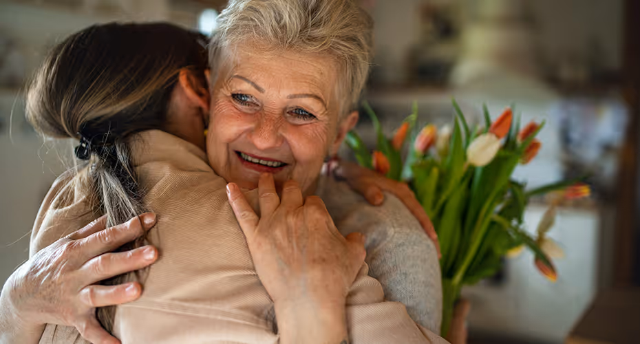 Femme senior souriante enlacée par une aide à domicile, illustrant la sérénité du CESU avec Provence Aide Services.
