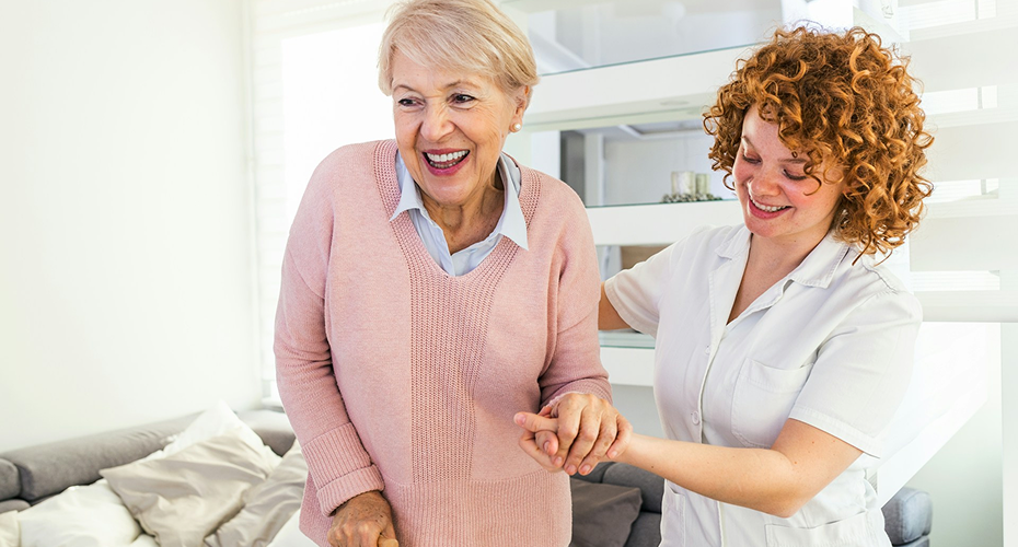 Assistante de vie souriante en mission de confiance au domicile d'un senior dans le Var.