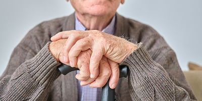 Personnes âgées avec les mains croisées sur sa canne