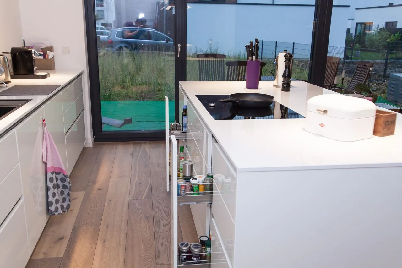 Designküche mit Kochinsel – Grifflose Küche in Weiß mit klarer Linienführung