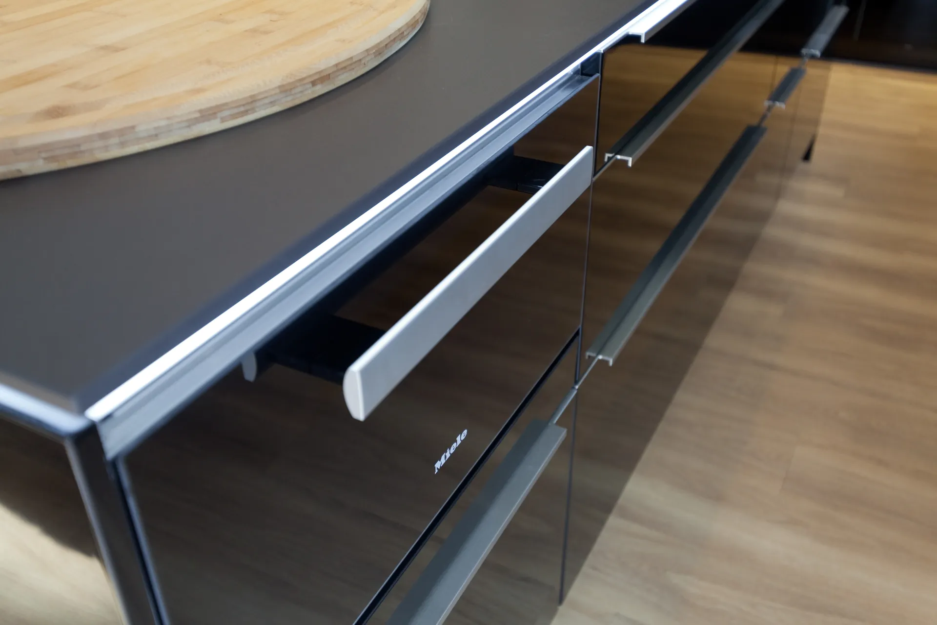 Designküche mit Kochinsel – Hochglanz Schwarz mit Naturstein-Arbeitsplatte